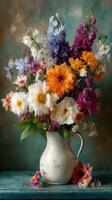 Vibrant bouquet of mixed seasonal flowers arranged in a white pitcher on a textured blue surface photo