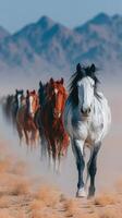 Horses roam gracefully across a desert landscape under a clear blue sky during twilight hours photo