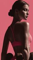 Fitness model showcasing strength in workout attire against a vibrant backdrop while holding weights photo