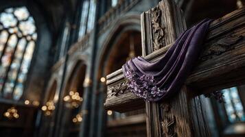 Religious cross adorned with purple cloth and flowers in an elegant church setting during daytime photo