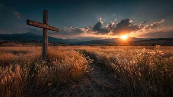 Golden sunset over rolling hills with wooden cross marking a quiet trail through tall grass fields photo