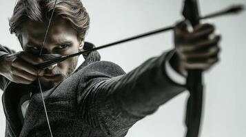 Man in suit aiming bow and arrow in dramatic pose during indoor target practice at a modern venue photo