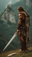 Warrior stands in a mountainous landscape holding a sword at sunset after a long battle photo