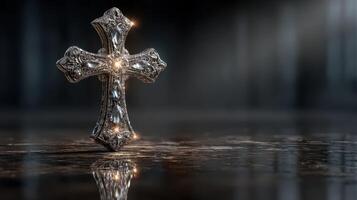 Intricate silver cross glows softly on a reflective surface in a dimly lit space, conveying a sense of serenity and spirituality photo
