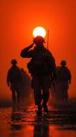 Soldiers salute at sunset during a military operation in a desert environment, honoring fallen comrades photo