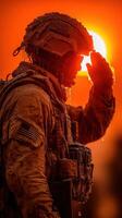 Soldier salutes at sunset, showcasing determination and resilience during a challenging mission in a rugged environment photo
