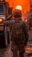 Soldier salutes at sunset during deployment in a military operation in a dusty environment photo