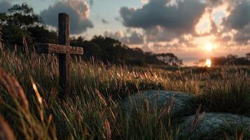 Sunset over a serene landscape with a wooden cross near the coast and gentle waves in the background photo