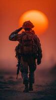 Soldier saluting at sunset during military operation in a desert landscape photo