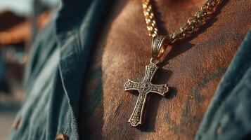 Golden cross pendant shines against skin with intricate tattoo design in outdoor setting photo