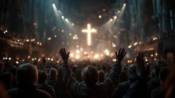 Crowd worships in a grand cathedral during an evening service with glowing cross photo