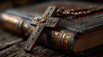 Intricate cross and rosary placed on an ancient leather-bound religious book in soft light photo
