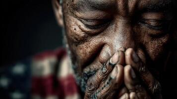 Elderly man with closed eyes praying indoors with hands clasped, captured in soft lighting showcasing deep emotions photo