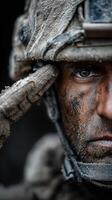 Soldier salutes with determination during training exercise in rugged terrain at dawn photo