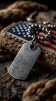 Military dog tag resting on textured fabric with an American flag motif during a solemn moment of remembrance photo