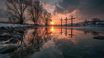 Scenic sunset over a calm river with three crosses and reflection in the water photo