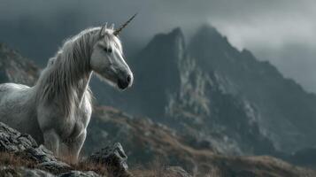 Majestic unicorn standing on rocky terrain with mountains in the background under a cloudy sky photo