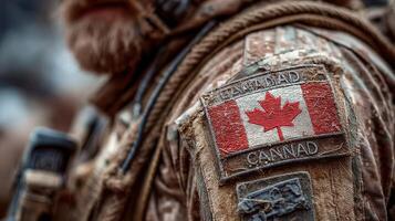 Canadian soldier wearing a patch with national flag while on a military operation in rugged terrain during daytime conditions photo