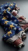 Textured fabric combining the flags of Europe and the United States draped on a dark surface photo