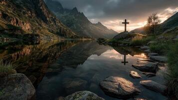 Sunrise over tranquil lake with mountain backdrop and a cross reflection in the water photo