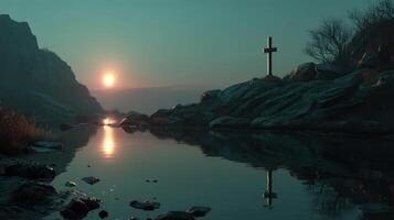 Serene sunset reflection at a rocky shoreline with a cross near tranquil water photo