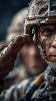 Soldier saluting with determination during a muddy training exercise in the early morning hours photo