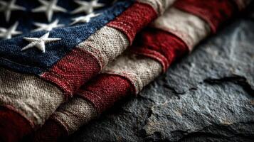Folded American flag resting on textured stone surface in a somber display of patriotism photo