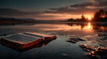 Serenity at dusk with an open book reflecting on calm waters under a warm sunset sky photo
