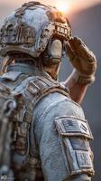 Military soldier saluting at sunset in rugged terrain with detailed tactical gear and a worn flag patch photo