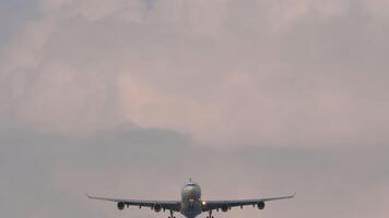 Front view of an airliner descending through sunset sky filled with clouds. Airplane approaching landing. Travel concept. video