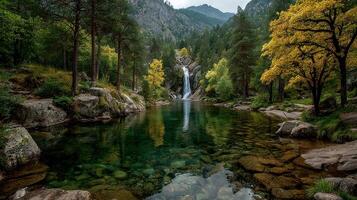 Waterfall cascading into a serene lake surrounded by autumn trees in a mountainous landscape during daytime photo