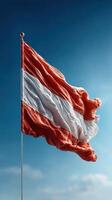 Austrian flag waving proudly against a clear blue sky during daytime photo