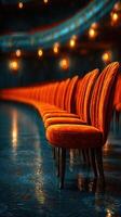 Chairs arranged in a theater create a warm ambiance as soft lighting highlights their vibrant color and elegant design photo
