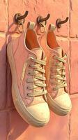 Unique hanging sneakers displayed on a textured wall ready for a fashionable outing in a vibrant setting photo