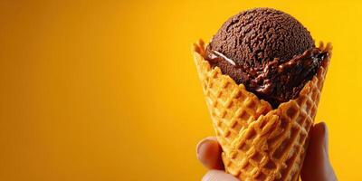 Enjoying a delicious chocolate ice cream cone with a vibrant yellow background on a sunny day photo