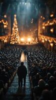 Crowd gathered in a theater for a holiday performance under festive lights and decorations photo