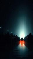 Audience gathered in a dark theater awaiting an experience, illuminated by a distant light and reflections on the floor photo