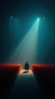 Empty theater filled with anticipation as a solitary figure sits under a spotlight photo