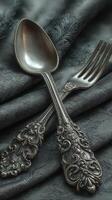 Elegant silverware placed on textured fabric, showcasing intricate detailing and craftsmanship in a soft, moody setting photo