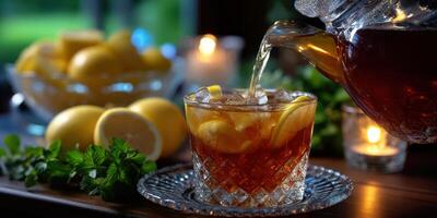 Refreshing iced tea being poured with lemons and mint in a cozy setting during a summer evening photo