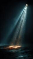 Bright light beam illuminating ground with shimmering particles in a dark environment at night photo