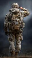 Soldier saluting while wearing tactical gear in a rugged landscape during a cloudy day photo