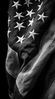 American flag draped in shadows with detailed texture visible against a dark background photo