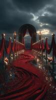 Elegant pathway adorned with red drapes and candles leading to a decorative arch under a moody sky at dusk photo