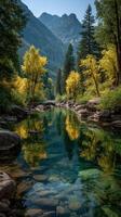 Tranquil river reflecting autumn colors in a mountain landscape during daytime photo