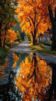 Scenic autumn road with vibrant orange trees reflecting on water near cozy house in a tranquil setting photo