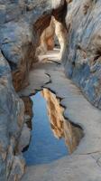 Beautiful rocky canyon with reflective water pool in a serene landscape during golden hour photo