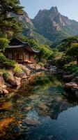 Charming temple by serene waterway surrounded by mountains in the early morning light photo