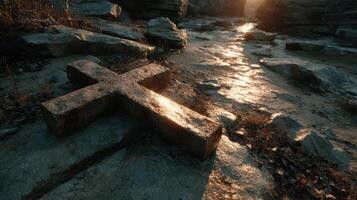 Cross on rocky ground illuminated by sunset in serene natural setting photo