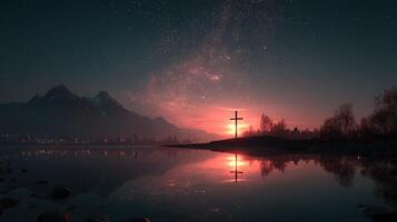 Sunset over tranquil lake with cross reflection and mountains in the backdrop during a starry evening photo